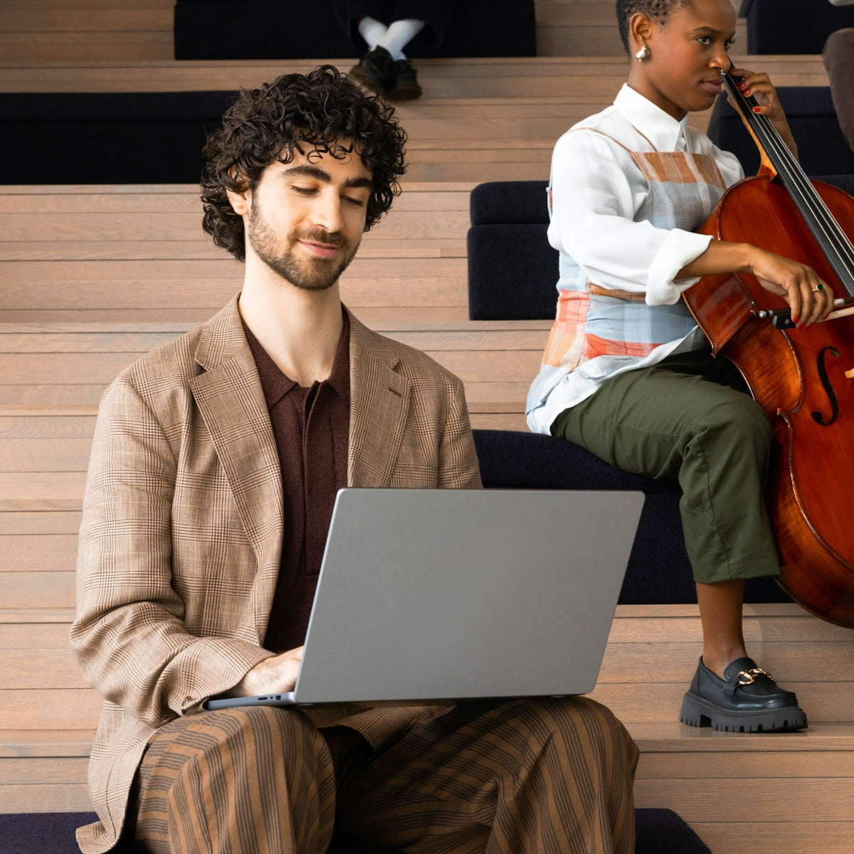 Man with laptop and woman playing cello