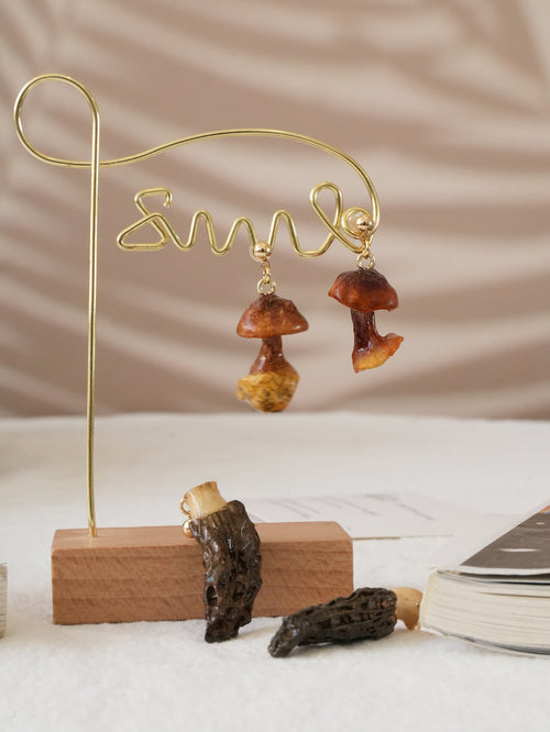 Close up of real Golden Chanterelle mushroom earring with amber resin finish.