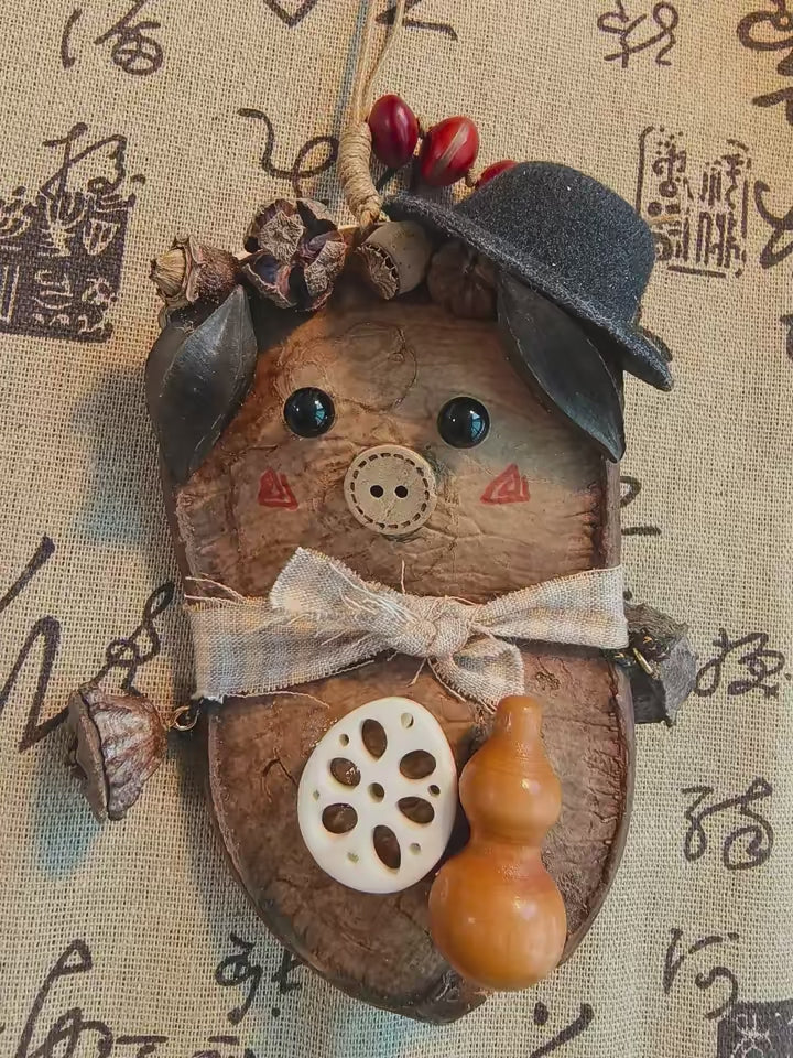 Entada pod character ornament with hat, bow, and gourd details on fabric