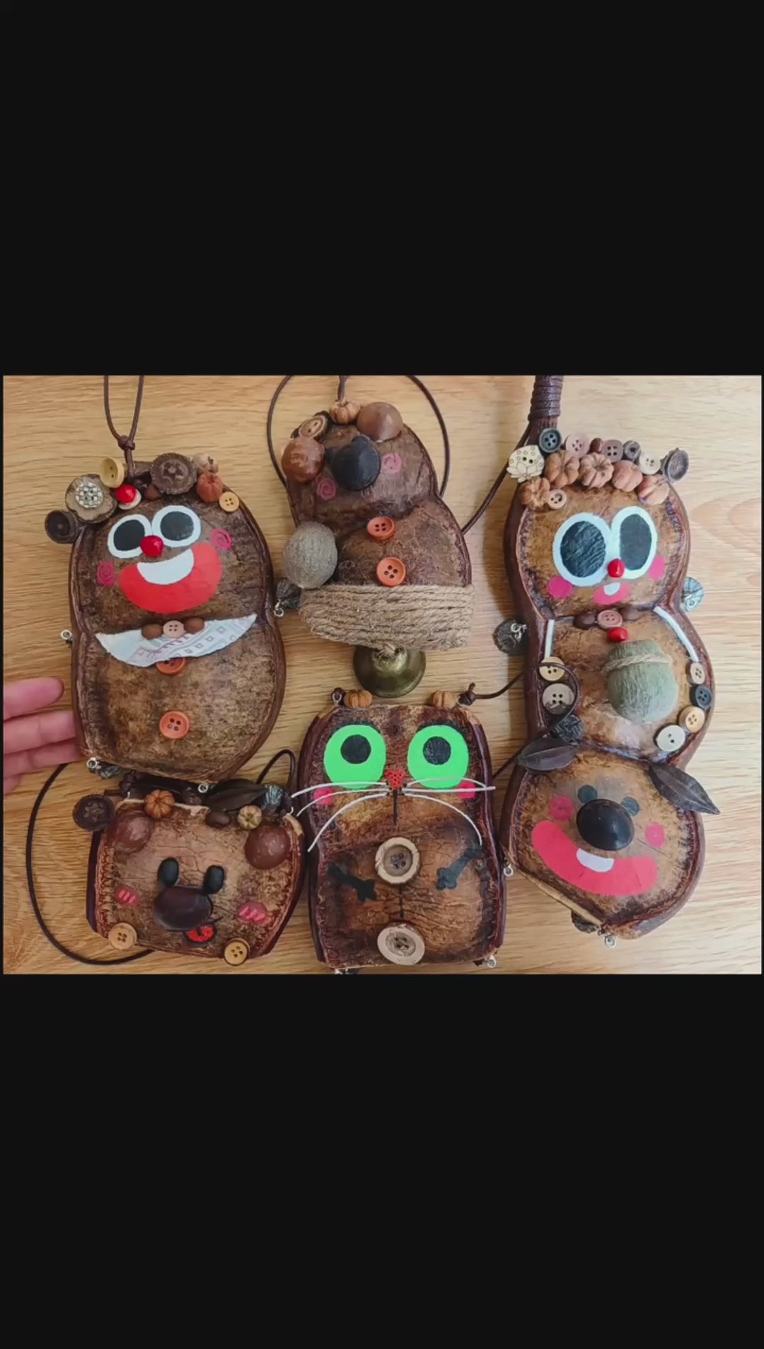 Group of playful Entada pod character ornaments with painted faces and seed details