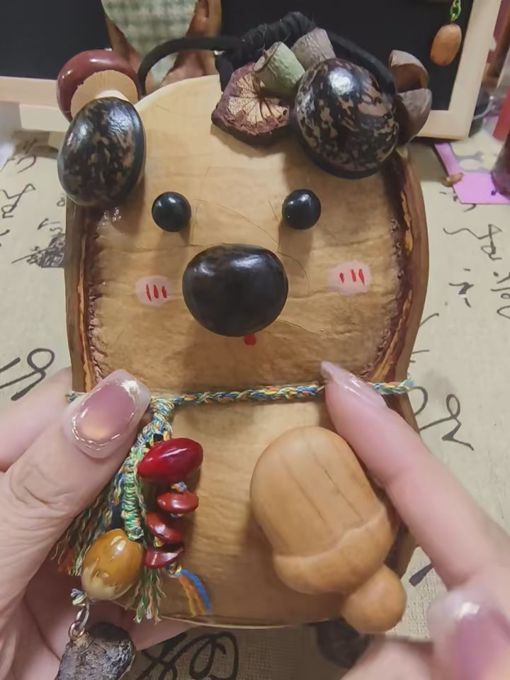 Bear-style Entada pod ornament with glossy seed charms held close-up