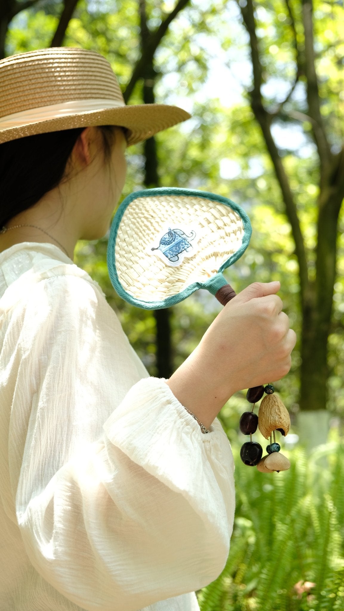 "The Lucky Breeze" - Hand - Woven Heart Palm Fan with Blue Elephant & Seed Charm - Yunicrafts