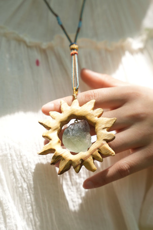 „Der Sonnenkristall“ – handgeschnitzter Sonnenanhänger aus Holz mit schwimmendem Rohedelstein – Yunicrafts
