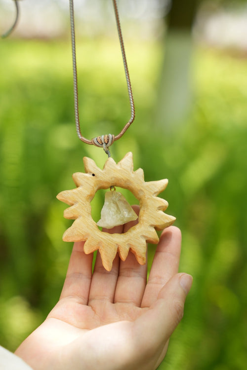 „Der Sonnenkristall“ – handgeschnitzter Sonnenanhänger aus Holz mit schwimmendem Rohedelstein – Yunicrafts